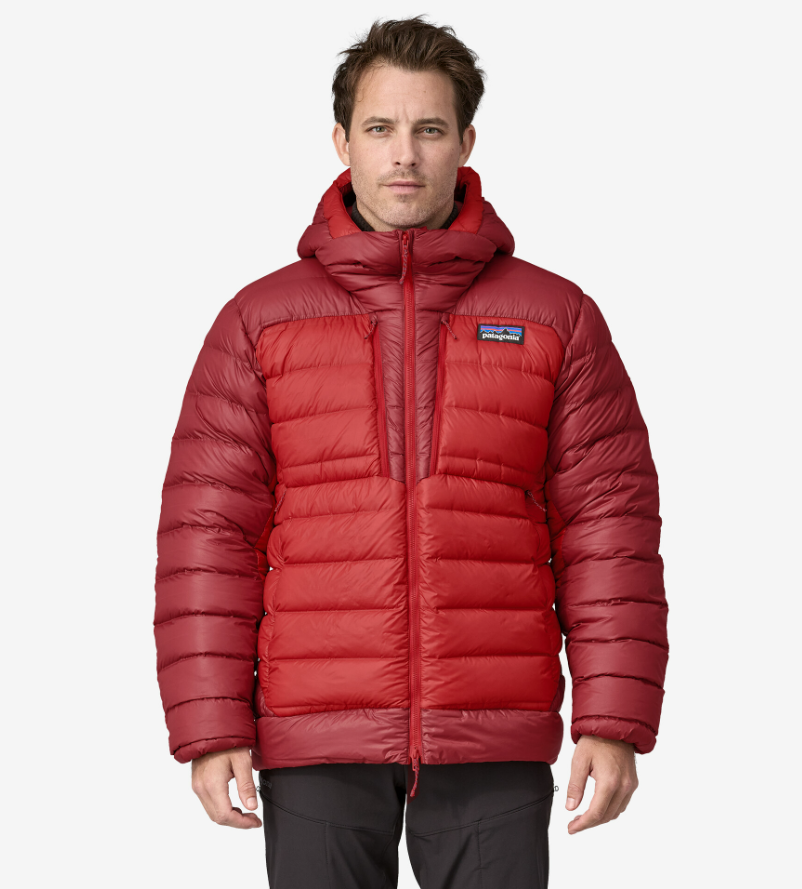 Man in a red down jacket with hood. The Patagonia logo is attached on the left chest area of the jacket.