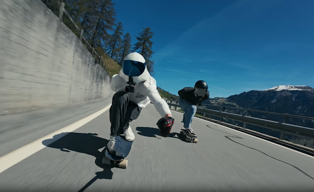 Two skateboarders cruising down a mountain road, captured by DJI Osmo Action 4. Thrilling adventure on wheels!