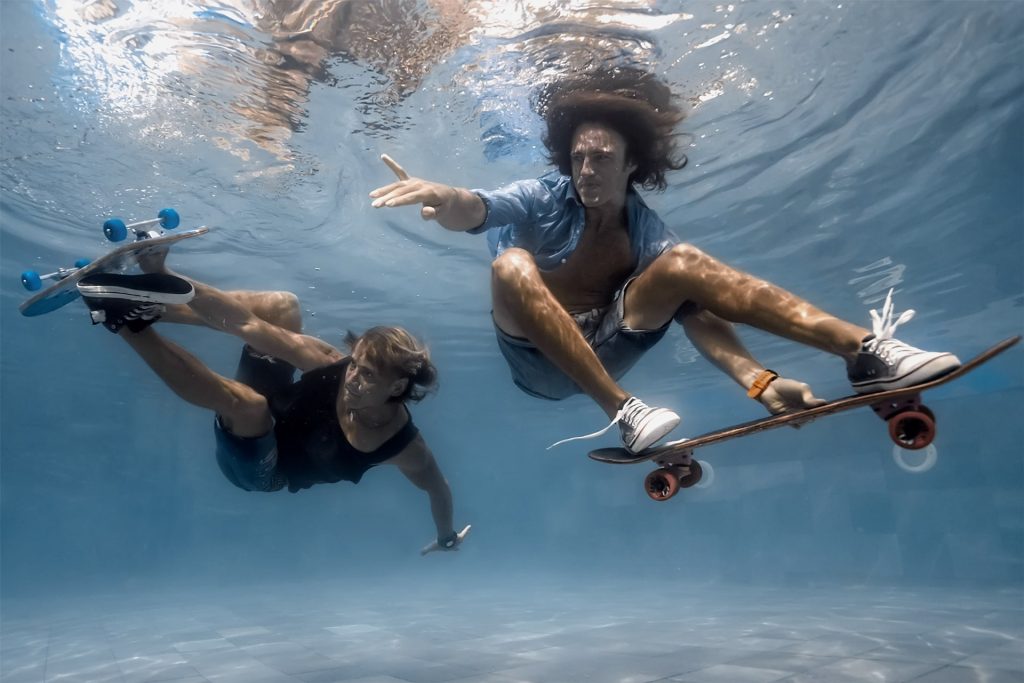 Two guys attempting to skateboard underwater, captured by Akaso Brave 7 LE.