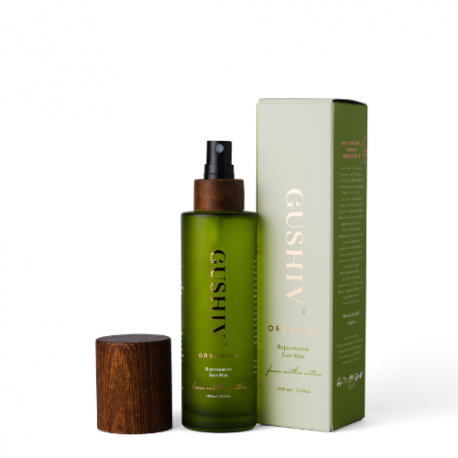 A Gushiv Organic face mist with a green body, wood-like cap, black spray dispenser, and whitish-green packaging, showcased against a white background.