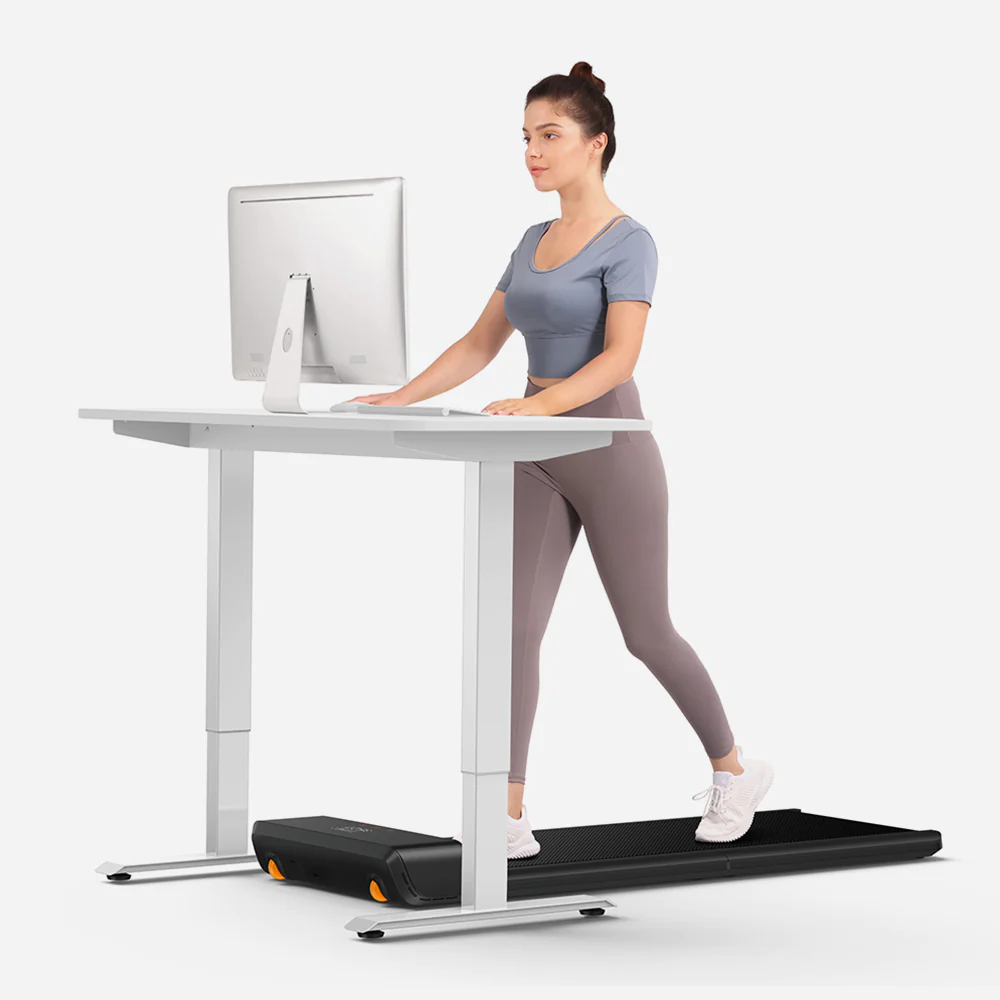 A multitasking woman on a treadmill, effortlessly using a computer while staying fit and productive.