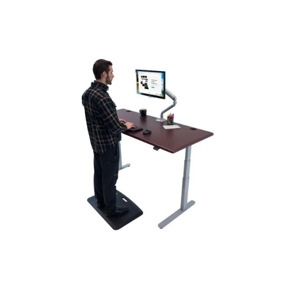 A man working at a standing desk with a computer.