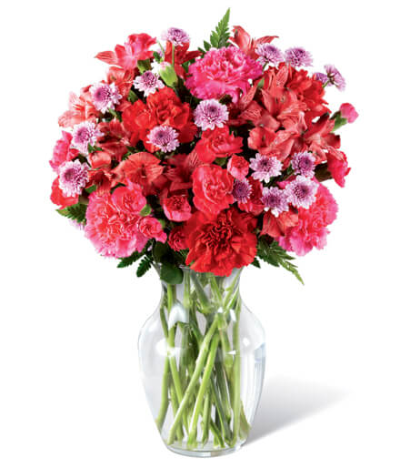 Flower arrangement in a clear glass vase featuring pink, red, and lavender blooms, shown as a classic Valentine’s bouquet.